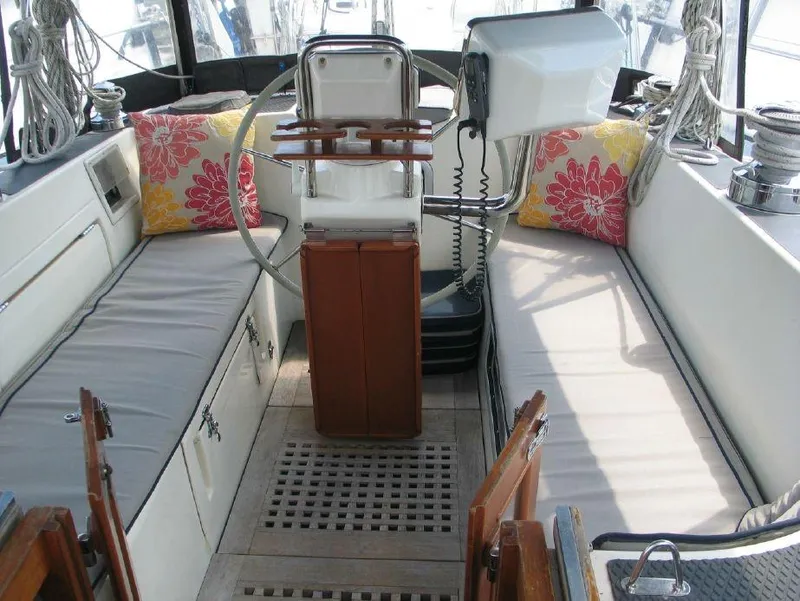 Slide: The Image of 1997 Westerly Oceanlord cockpit with cushioned seating, steering wheel, and vibrant floral pillows. - 18