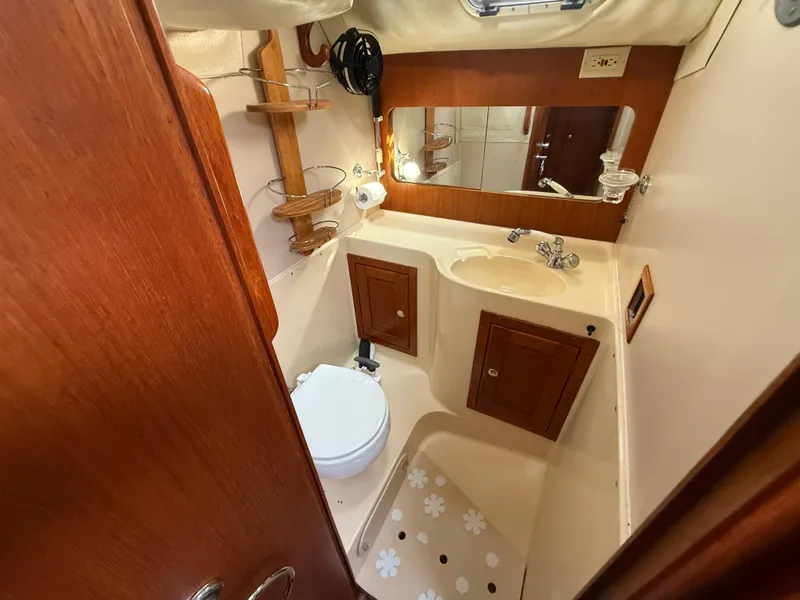 Slide: The Image of 1997 Westerly Oceanlord yacht bathroom with wooden cabinets, sink, and toilet. - 39