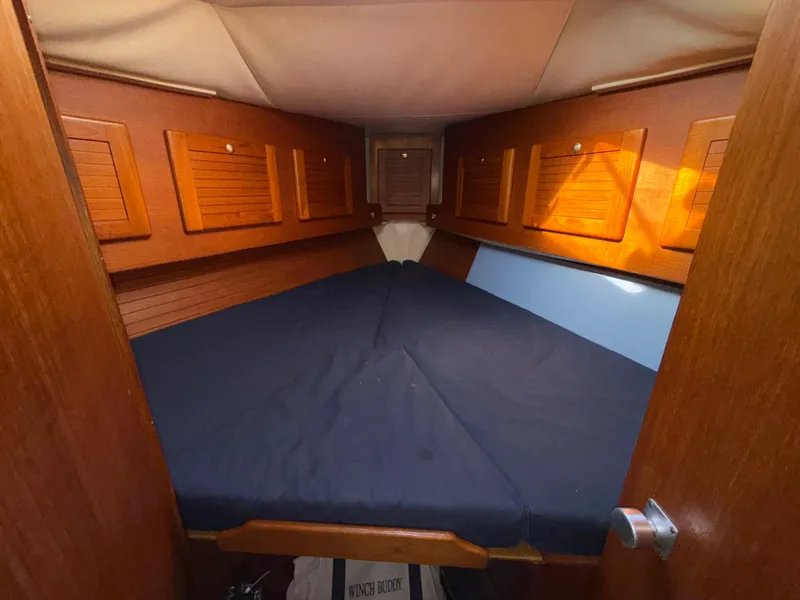 Slide: The Image of 1997 Westerly Oceanlord cabin with wooden interior and blue bedding. - 42
