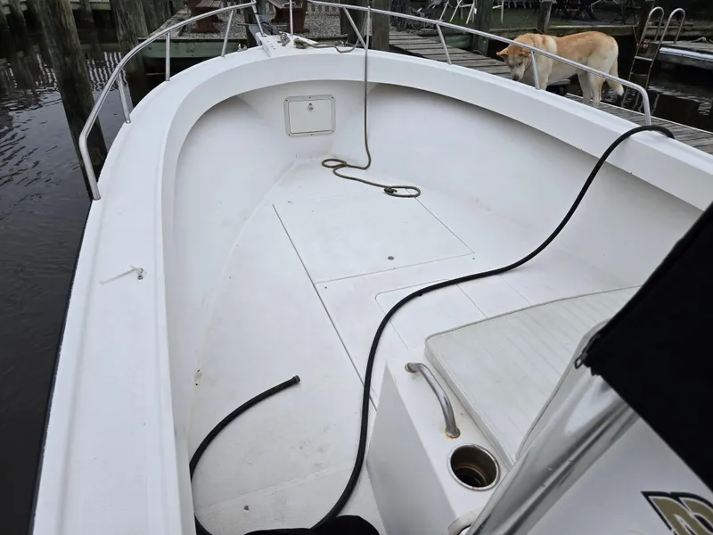 Slide: The Image of 1999 Shamrock 220 Open boat interior with white deck and railing, docked near water. - 10