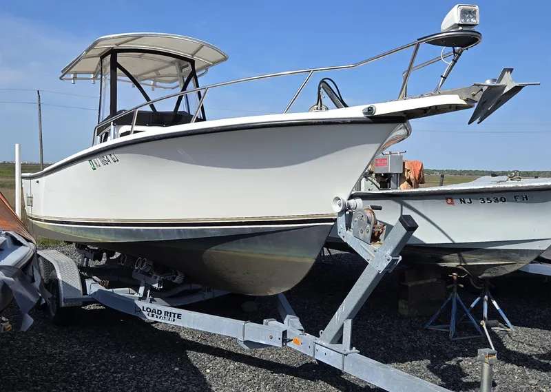 Slide: The Image of 1999 Shamrock 220 Open boat on trailer, side view, clear sky background. - 14