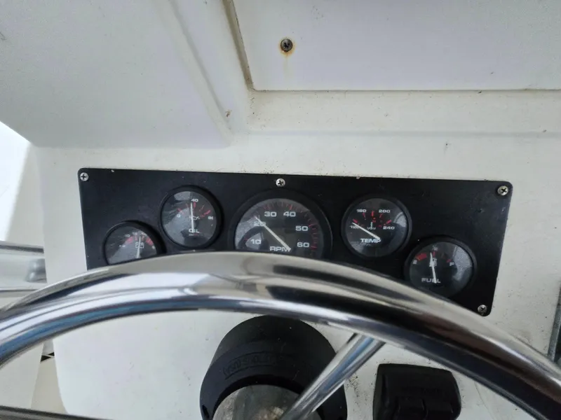 Slide: The Image of Dashboard of a 1999 Shamrock 220 Open boat with gauges and steering wheel. - 5