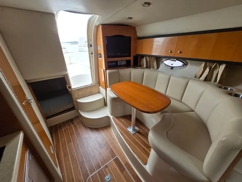 Slide: The Image of 2008 Chaparral 290 Signature interior with wood flooring, curved seating, and a mounted TV. - 2