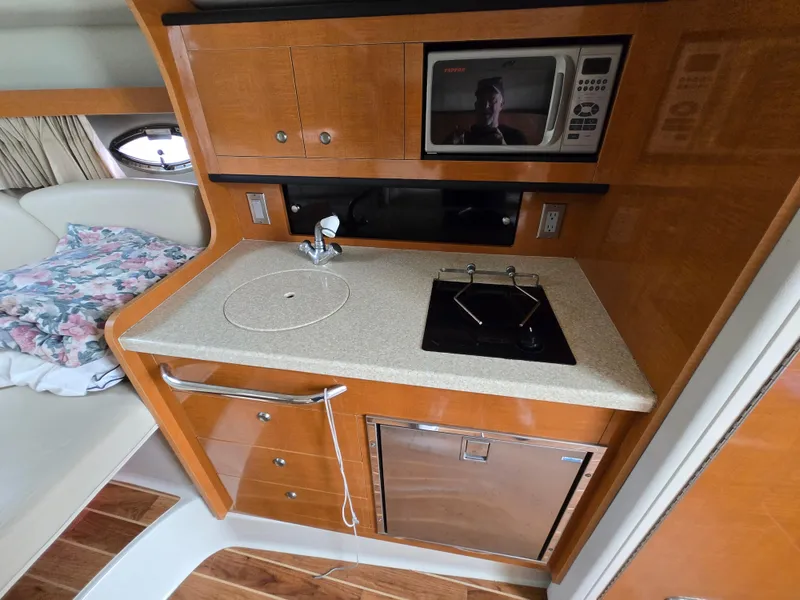 Slide: The Image of Compact kitchen area in a 2008 Chaparral 290 Signature boat with microwave and sink. - 21