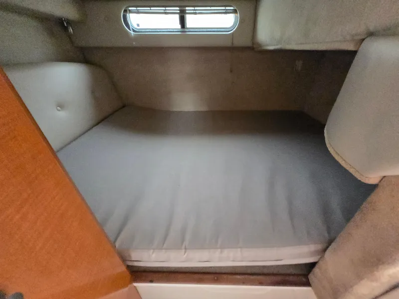 Slide: The Image of 2008 Chaparral 290 Signature cabin interior with bed and small window. - 24