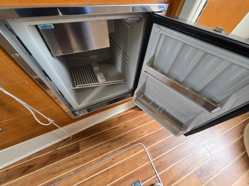 Slide: The Image of Open refrigerator inside a 2008 Chaparral 290 Signature boat, showing interior shelves and door storage. - 25