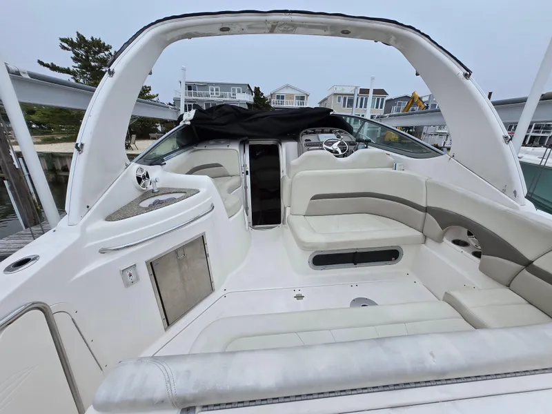 Slide: The Image of 2008 Chaparral 290 Signature boat interior with white seating and helm, docked at marina. - 3