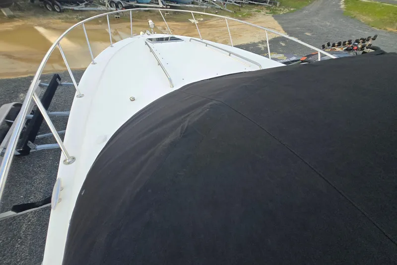 Slide: The Image of 2008 Chaparral 290 Signature boat deck with black cover, parked on gravel. - 46