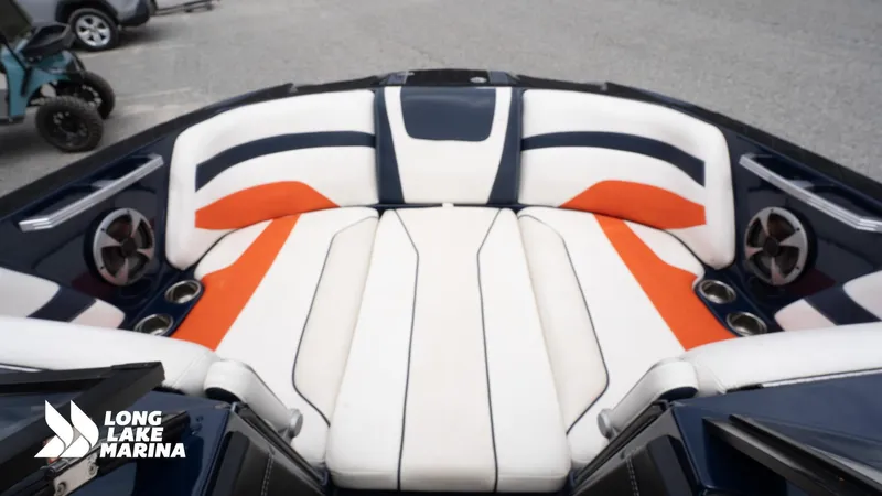 Slide: The Image of 2019 Malibu MXZ boat interior with white, orange, and black seating at Long Lake Marina. - 13