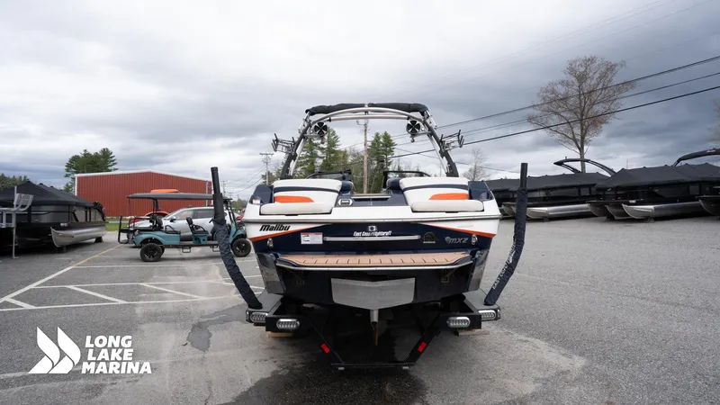 Slide: The Image of 2019 Malibu MXZ boat at Long Lake Marina, parked with other watercraft. - 7