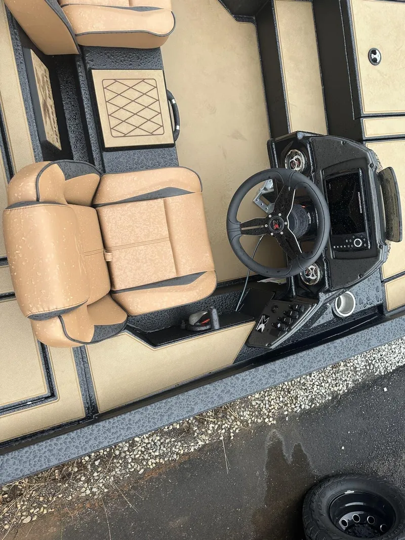 Slide: The Image of 2025 Xpress Hyper-Lift Bass Series boat interior with tan seats and modern steering console. - 8