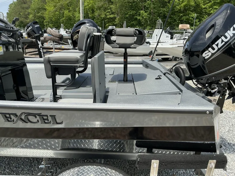 Slide: The Image of 2025 Excel Bay Pro 203 Elite boat with Suzuki outboard motor, parked on gravel. - 6