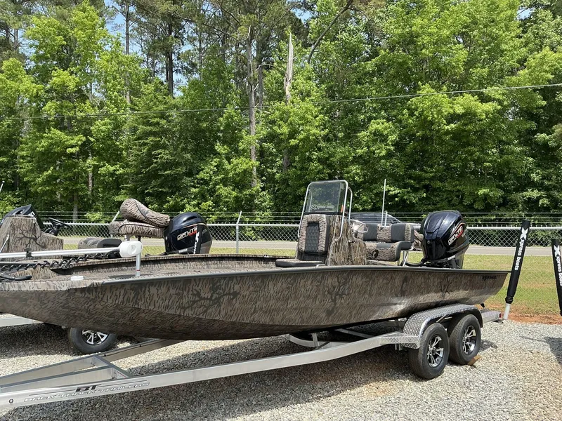 Slide: The Image of 2025 Xpress Hyper-Lift Series H22B boat on trailer, parked outdoors with trees in background. - 2