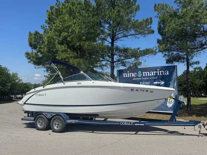 Slide: The Image of 2015 Cobalt R3 boat on trailer at Nine Marina, surrounded by trees. - 1