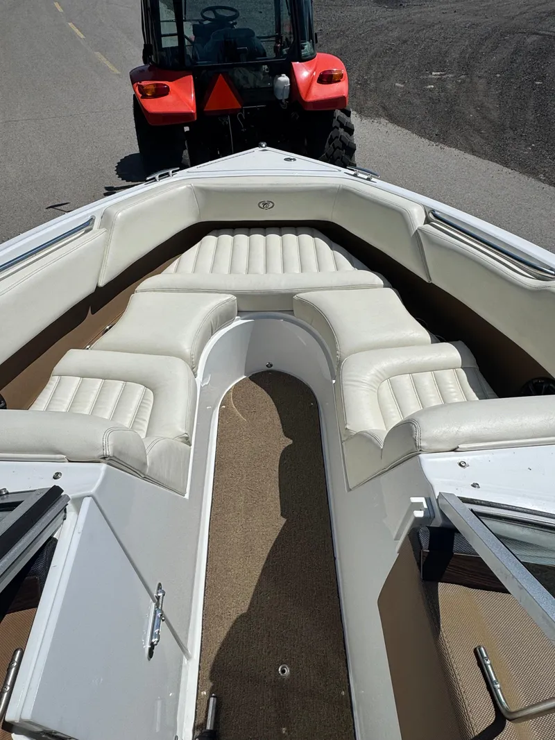 Slide: The Image of 2015 Cobalt R3 boat interior with white seating, towed by a red tractor. - 4