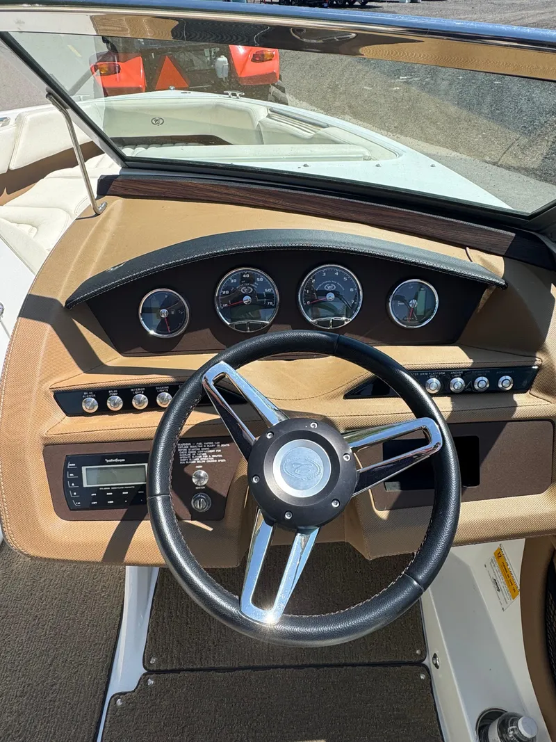 Slide: The Image of Steering wheel and dashboard of a 2015 Cobalt R3 boat, featuring gauges and controls. - 5