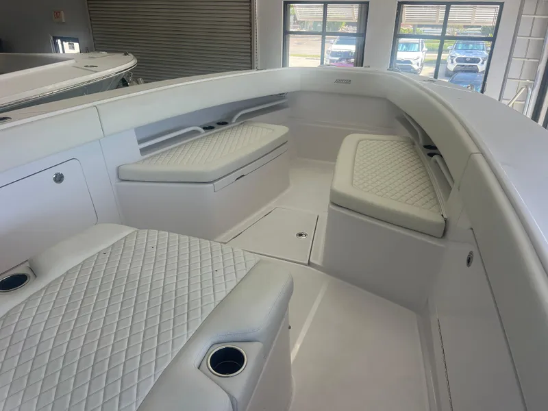 Slide: The Image of 2022 Jupiter 34 FS boat interior with white cushioned seating and cup holders. - 2