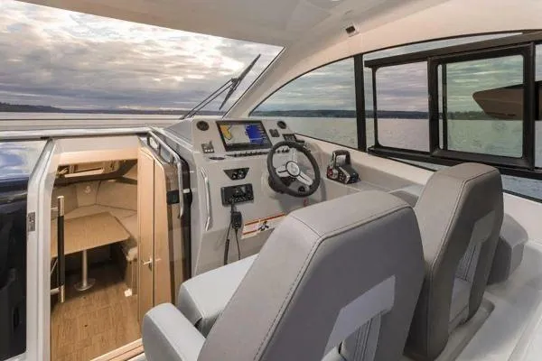 Slide: The Image of 2023 Beneteau GT32 boat interior with helm, seating, and cabin view. - 10