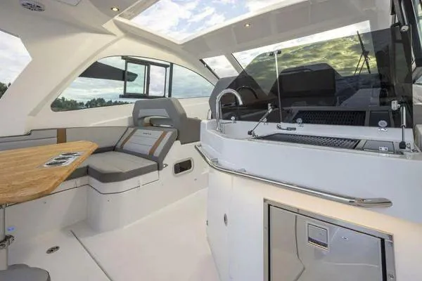 Slide: The Image of 2023 Beneteau GT32 interior with seating, table, and helm, showcasing modern design and comfort. - 11