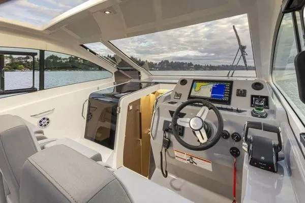 Slide: The Image of 2023 Beneteau GT32 boat interior with modern helm, steering wheel, and navigation system. - 13