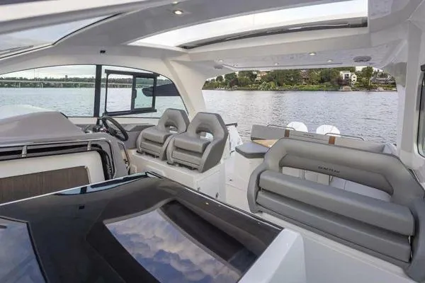 Slide: The Image of 2023 Beneteau GT32 yacht interior with modern seating and panoramic water view. - 14