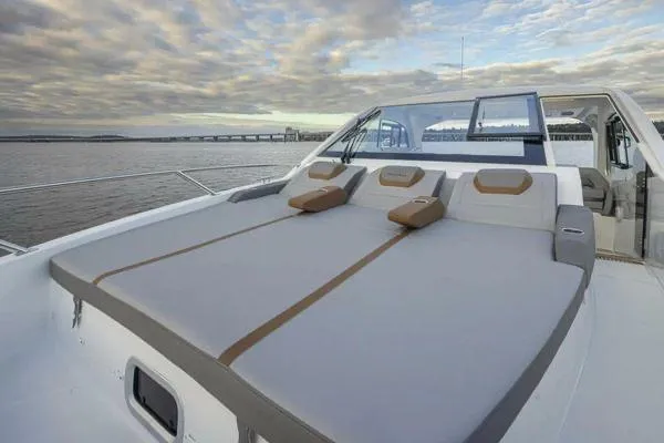 Slide: The Image of 2023 Beneteau GT32 yacht with spacious sunbathing deck, overlooking serene waters and cloudy sky. - 8