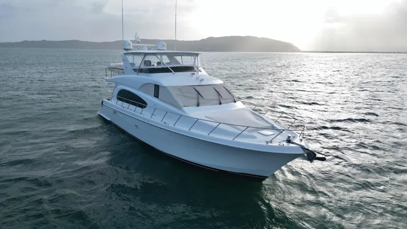 Slide: The Image of 2006 Hatteras 64 Motor Yacht cruising on open water at sunset. - 12