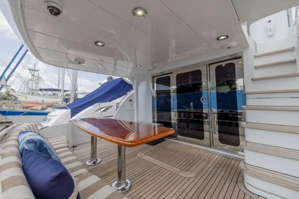 Slide: The Image of 2006 Hatteras 64 Motor Yacht deck with seating, table, and stairs. - 14