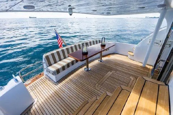 Slide: The Image of Luxurious 2006 Hatteras 64 Motor Yacht deck with seating, table, and ocean view. - 15
