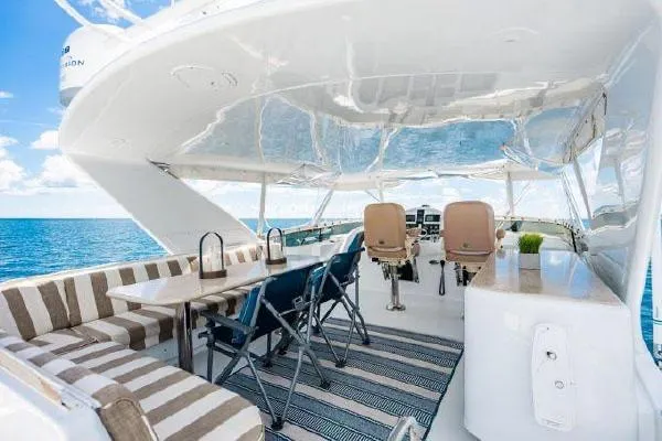 Slide: The Image of 2006 Hatteras 64 Motor Yacht deck with seating, table, and ocean view. - 17