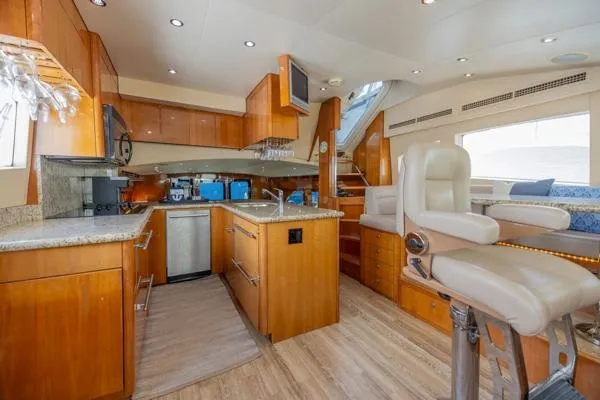 Slide: The Image of Luxurious interior of 2006 Hatteras 64 Motor Yacht with modern kitchen and seating area. - 31