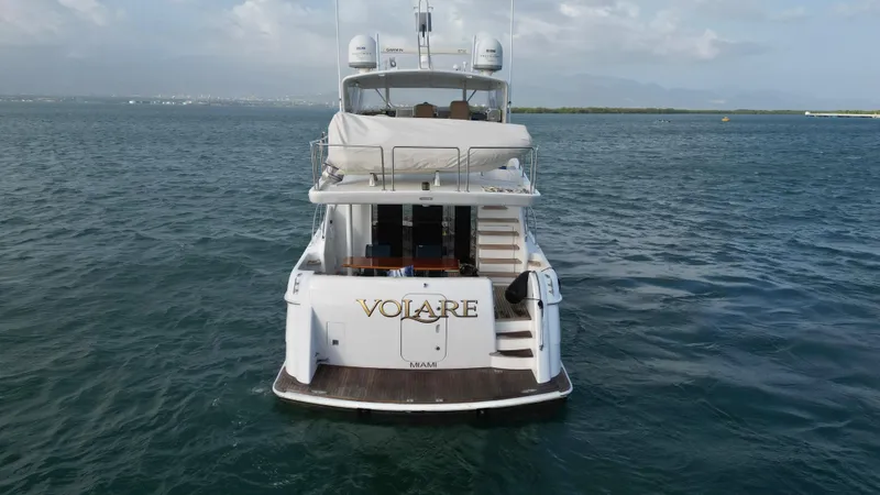 Slide: The Image of 2006 Hatteras 64 Motor Yacht on open water, rear view, with "Volare" name visible. - 7