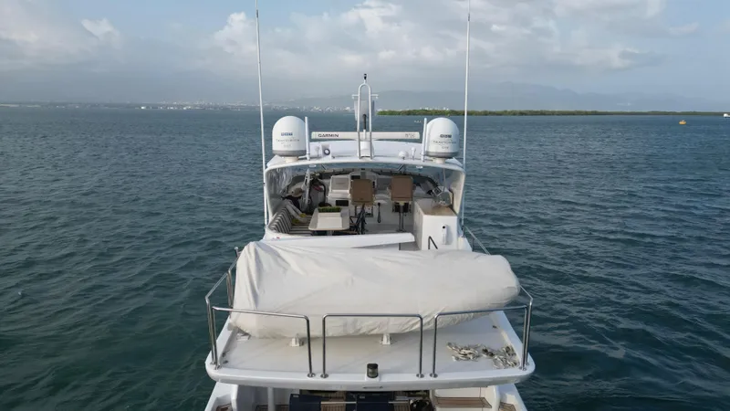 Slide: The Image of 2006 Hatteras 64 Motor Yacht on calm waters, rear view with covered equipment. - 8