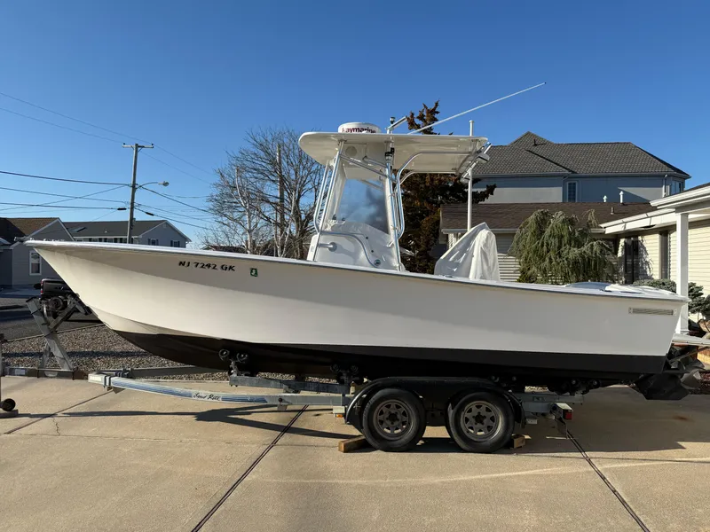 Slide: The Image of 2001 Silverhawk 24 Center Console boat on trailer, parked in driveway under clear blue sky. - 10