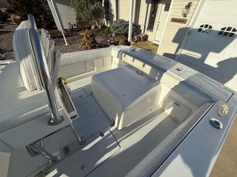 Slide: The Image of 2001 Silverhawk 24 Center Console boat interior with seating and storage, parked in a driveway. - 17