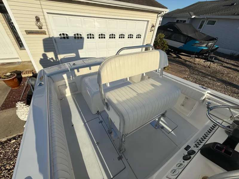 Slide: The Image of 2001 Silverhawk 24 Center Console boat with white seating, parked near a garage. - 19