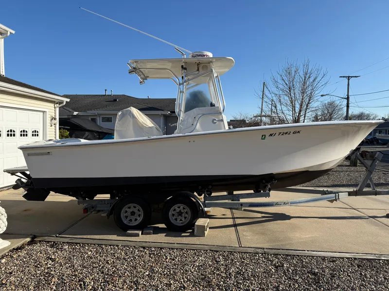 Slide: The Image of 2001 Silverhawk 24 Center Console boat on trailer in driveway. - 2