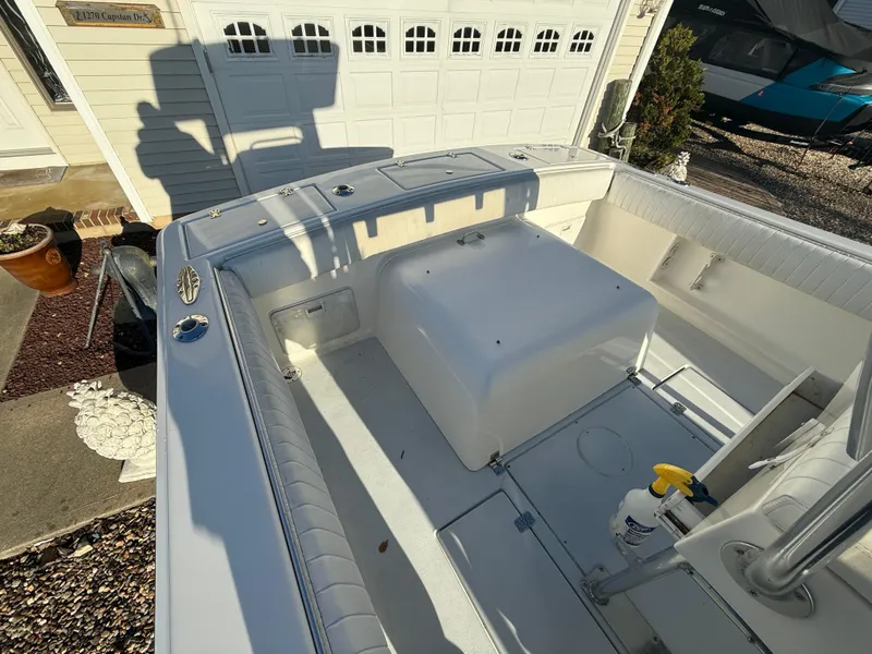 Slide: The Image of 2001 Silverhawk 24 Center Console boat, white interior, parked near a garage. - 20