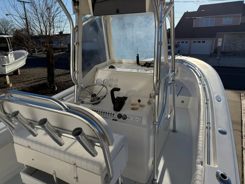 Slide: The Image of 2001 Silverhawk 24 Center Console boat with helm and seating, parked outdoors. - 22