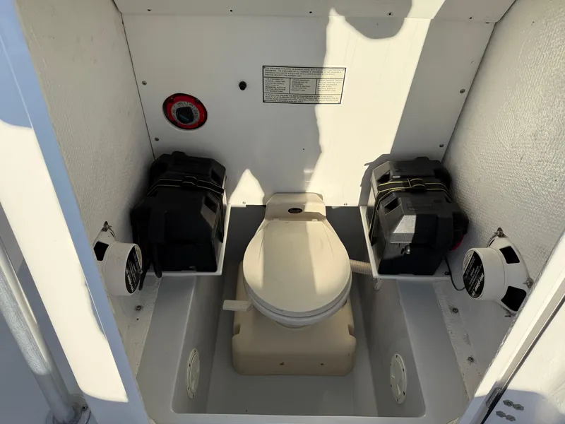 Slide: The Image of 2001 Silverhawk 24 Center Console boat toilet compartment with battery storage. - 31