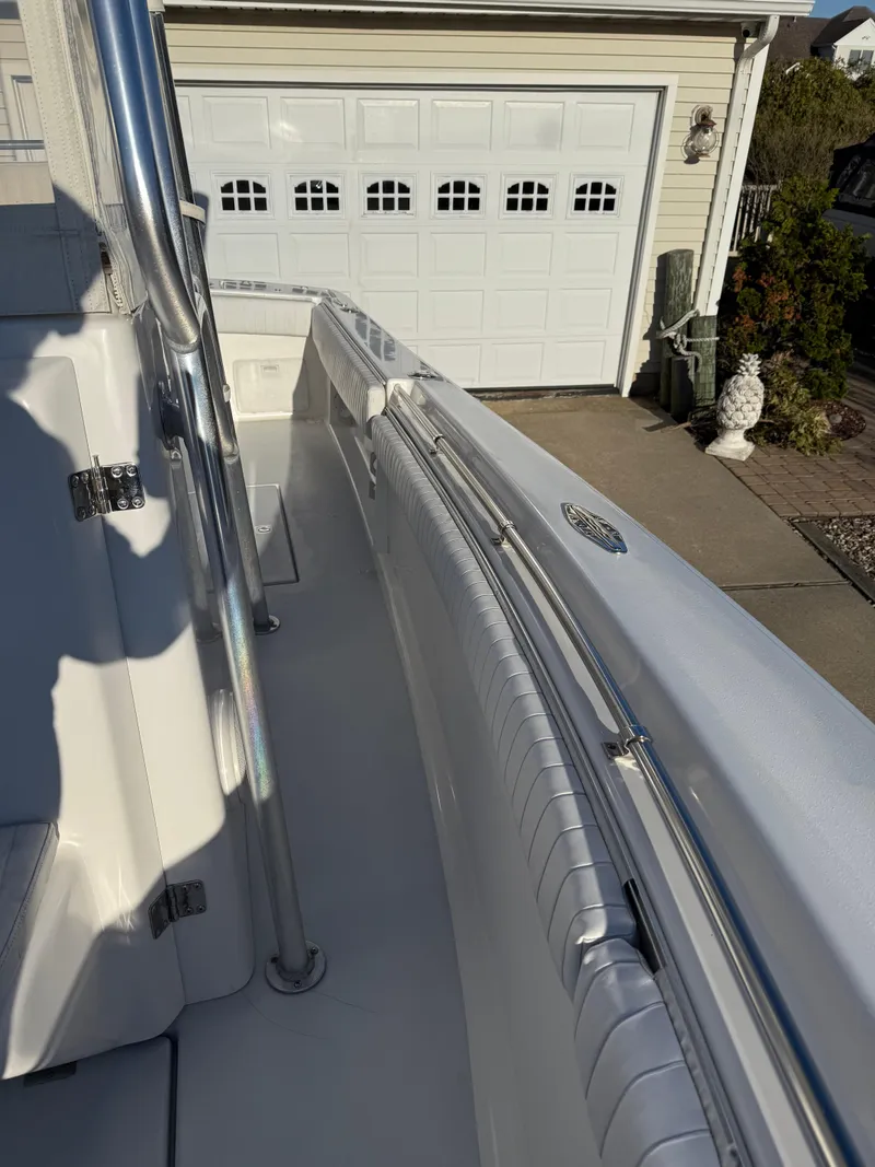 Slide: The Image of 2001 Silverhawk 24 Center Console boat, white interior, parked near a garage. - 34