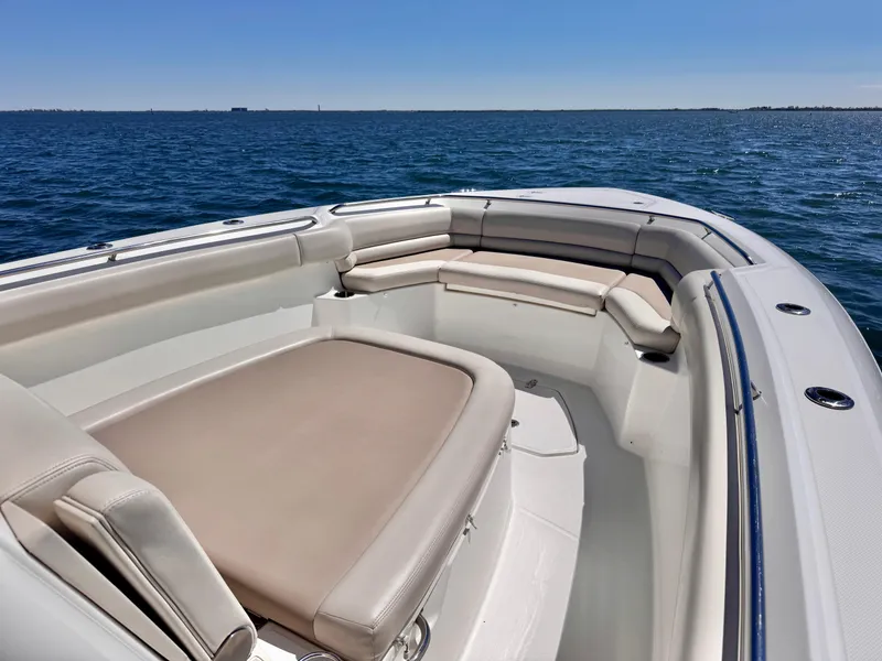 Slide: The Image of 2018 Boston Whaler 330 Outrage boat interior with cushioned seating on open water. - 13
