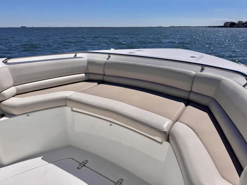 Slide: The Image of 2018 Boston Whaler 330 Outrage boat interior with cushioned seating, ocean view. - 14