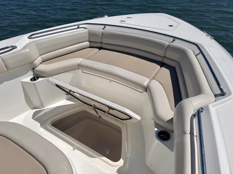 Slide: The Image of 2018 Boston Whaler 330 Outrage boat interior with cushioned seating and storage compartment. - 15