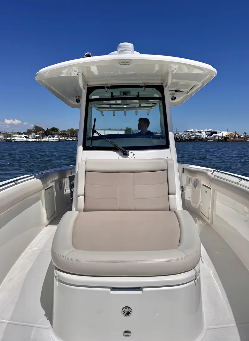 Slide: The Image of 2018 Boston Whaler 330 Outrage boat on water, featuring spacious seating and sleek design. - 18