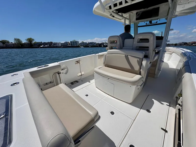 Slide: The Image of 2018 Boston Whaler 330 Outrage boat interior with seating, on calm water. - 2