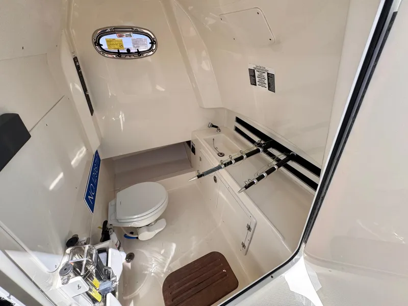 Slide: The Image of 2018 Boston Whaler 330 Outrage interior with toilet and fishing rod storage. - 24