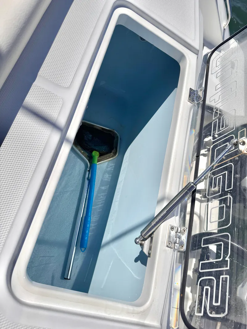 Slide: The Image of Open storage compartment on 2018 Boston Whaler 330 Outrage boat, featuring a blue interior. - 25