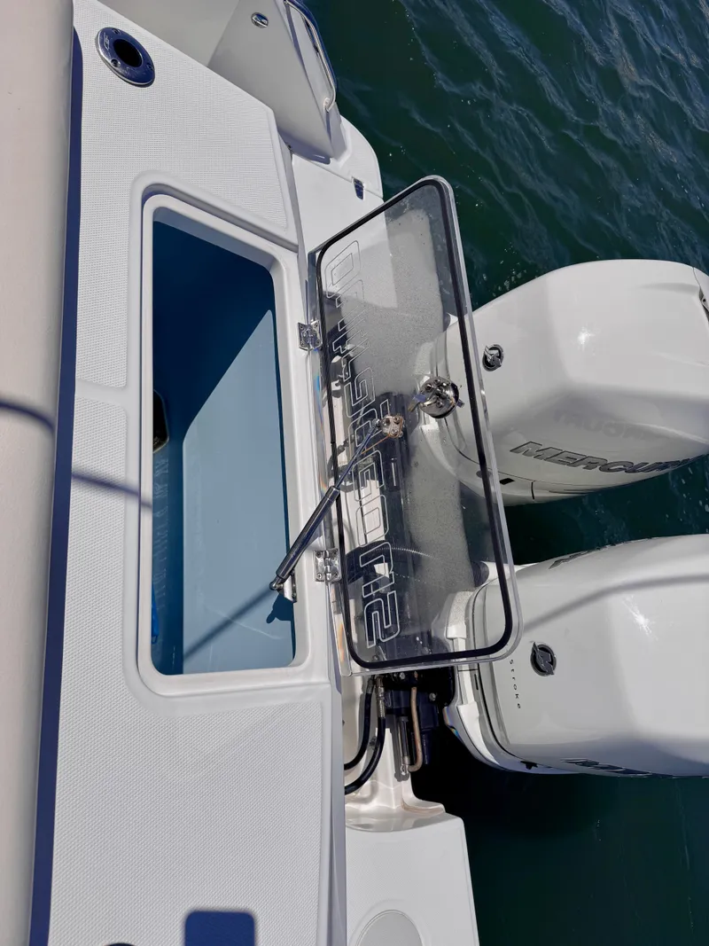 Slide: The Image of 2018 Boston Whaler 330 Outrage boat with open hatch and twin Mercury engines. - 26