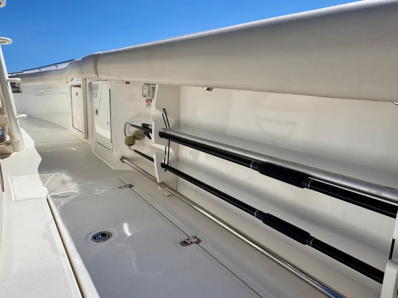 Slide: The Image of 2018 Boston Whaler 330 Outrage interior with rod holders and storage compartments. - 27